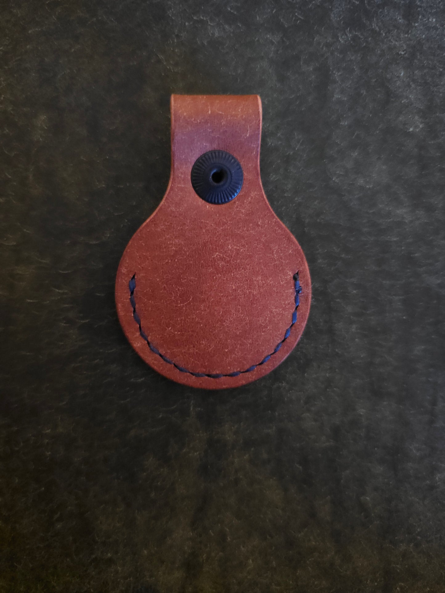 Back of circular leather air tag holder.