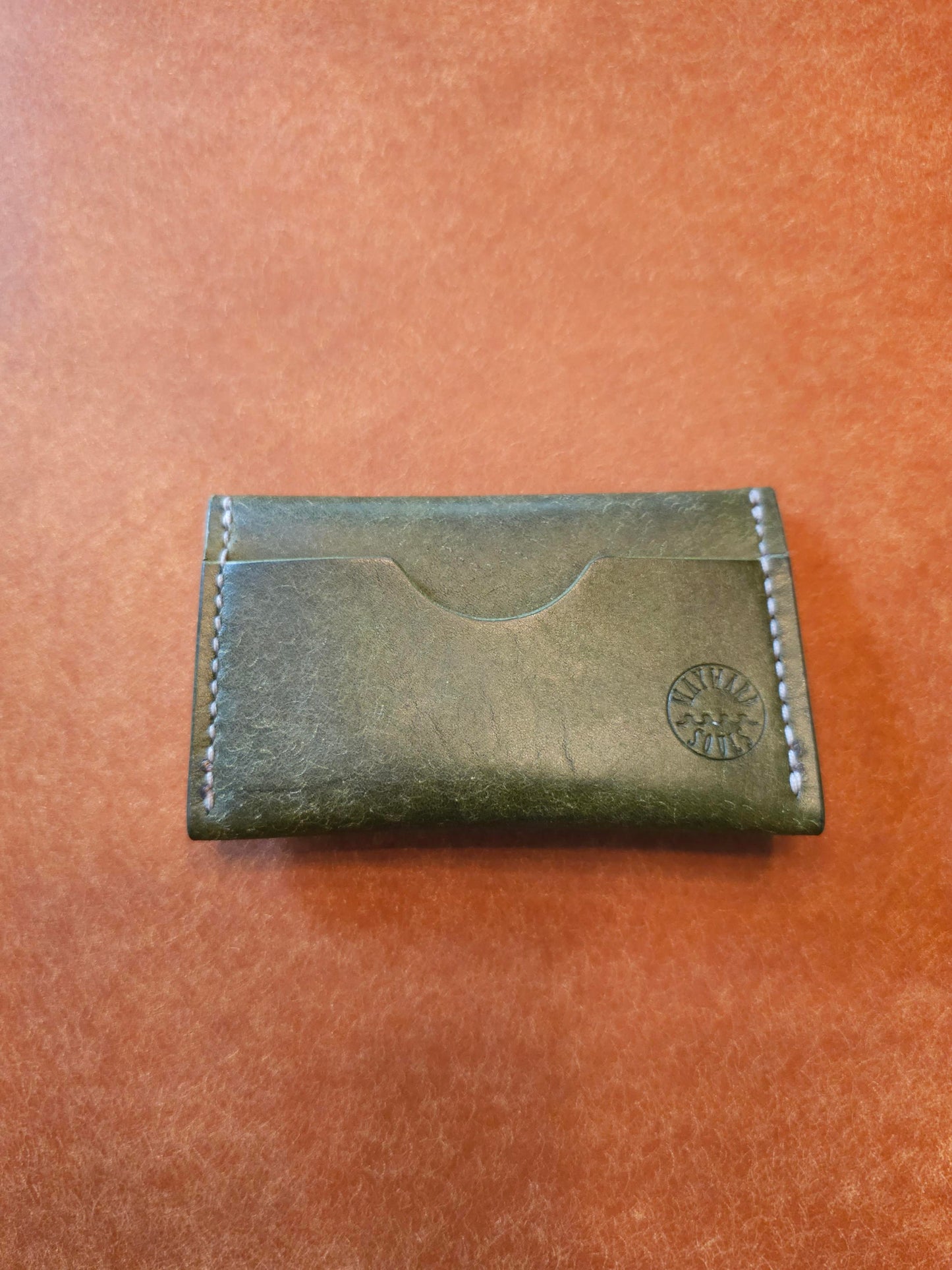 Back of card holder with a single pocket. The Wayward Souls logo in stamped in the bottom right corner.