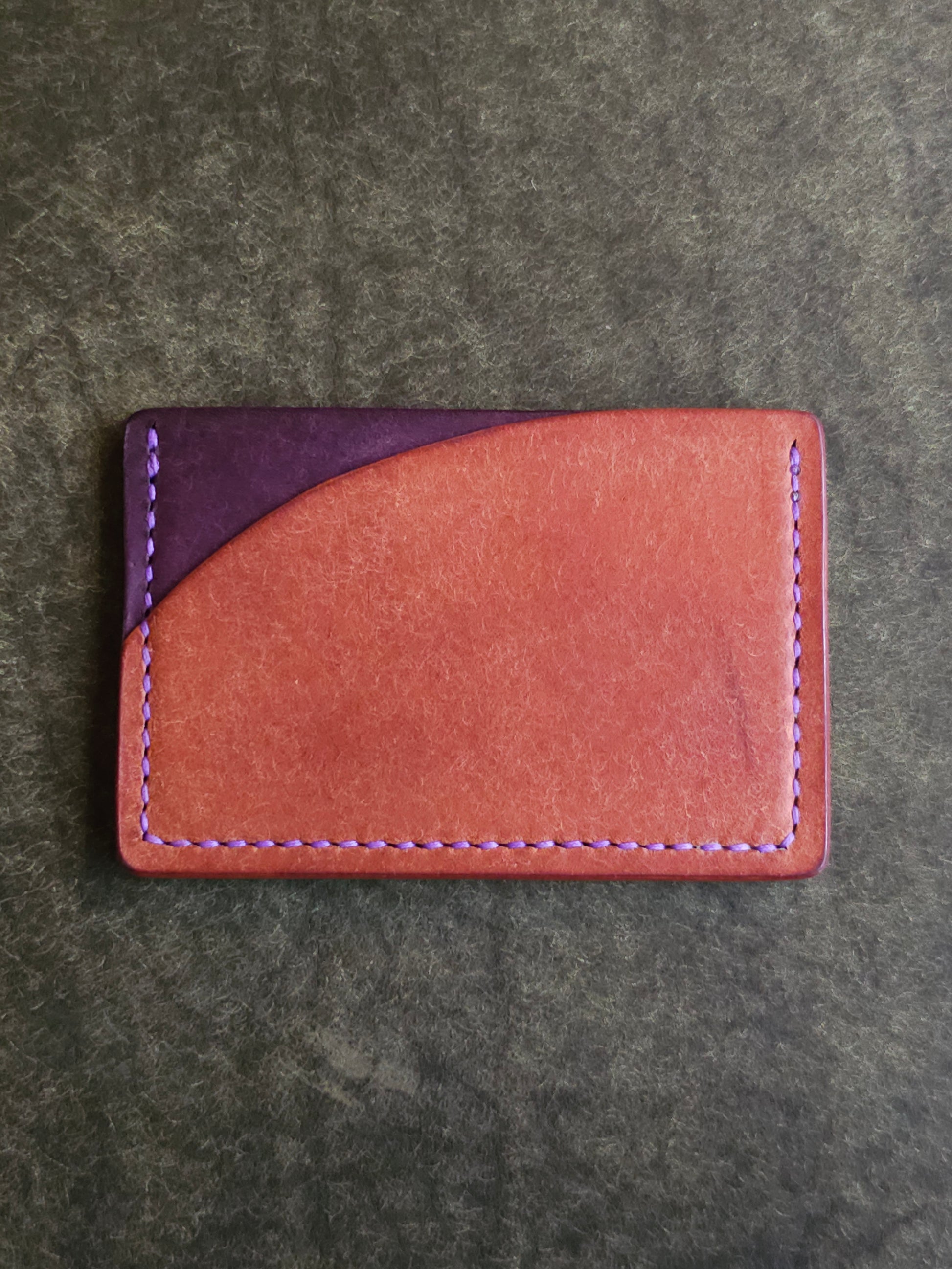 Back of leather card holder with pocket shaped like a sunset.