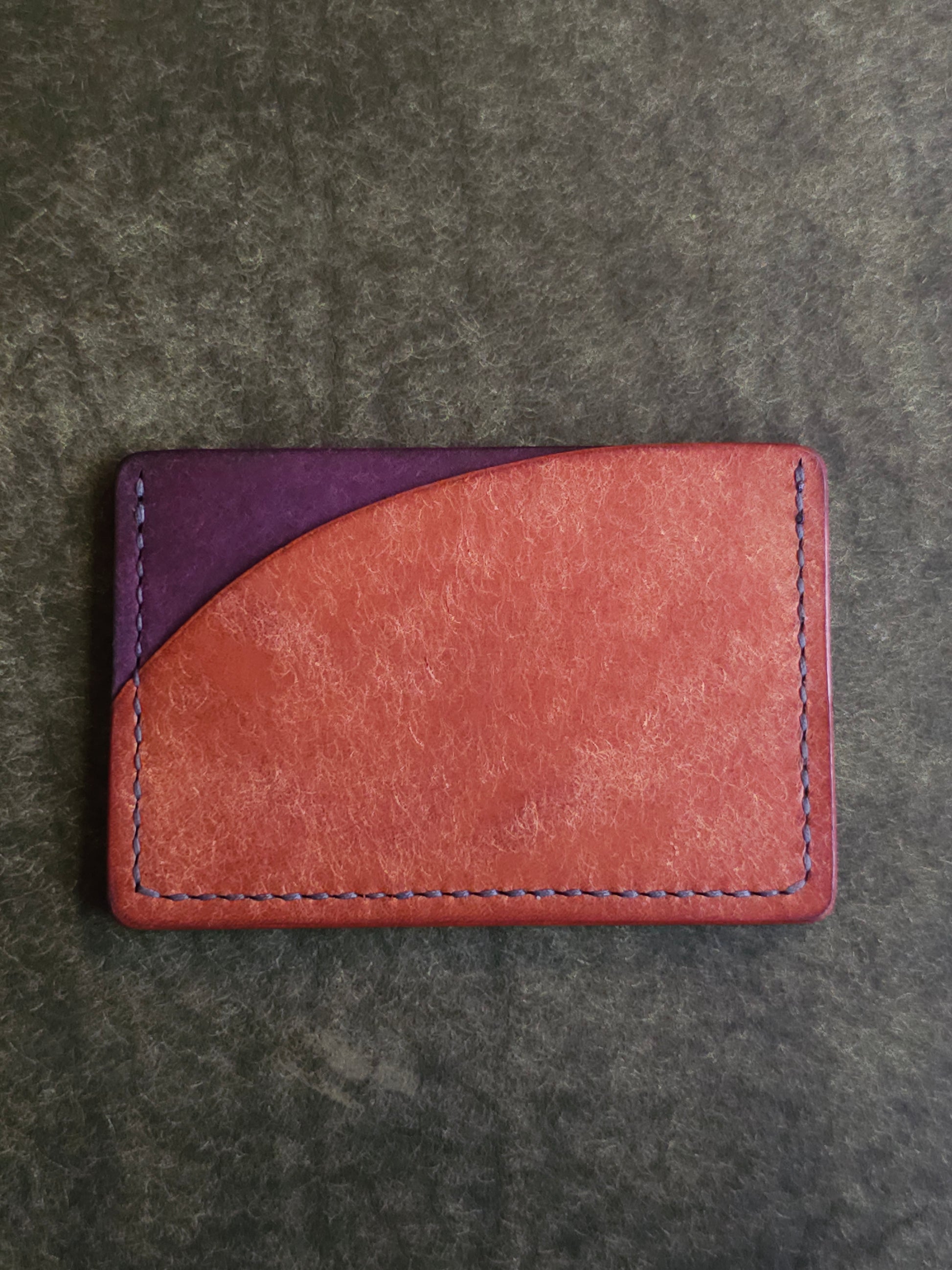 Back of leather card holder with pocket shaped like a sunset.