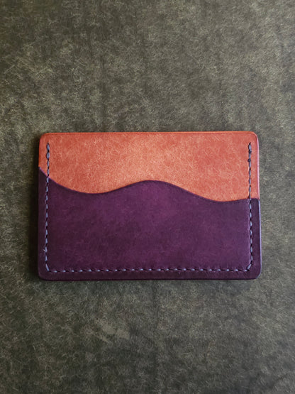 Back of leather card holder with pocket shaped like a wave.
