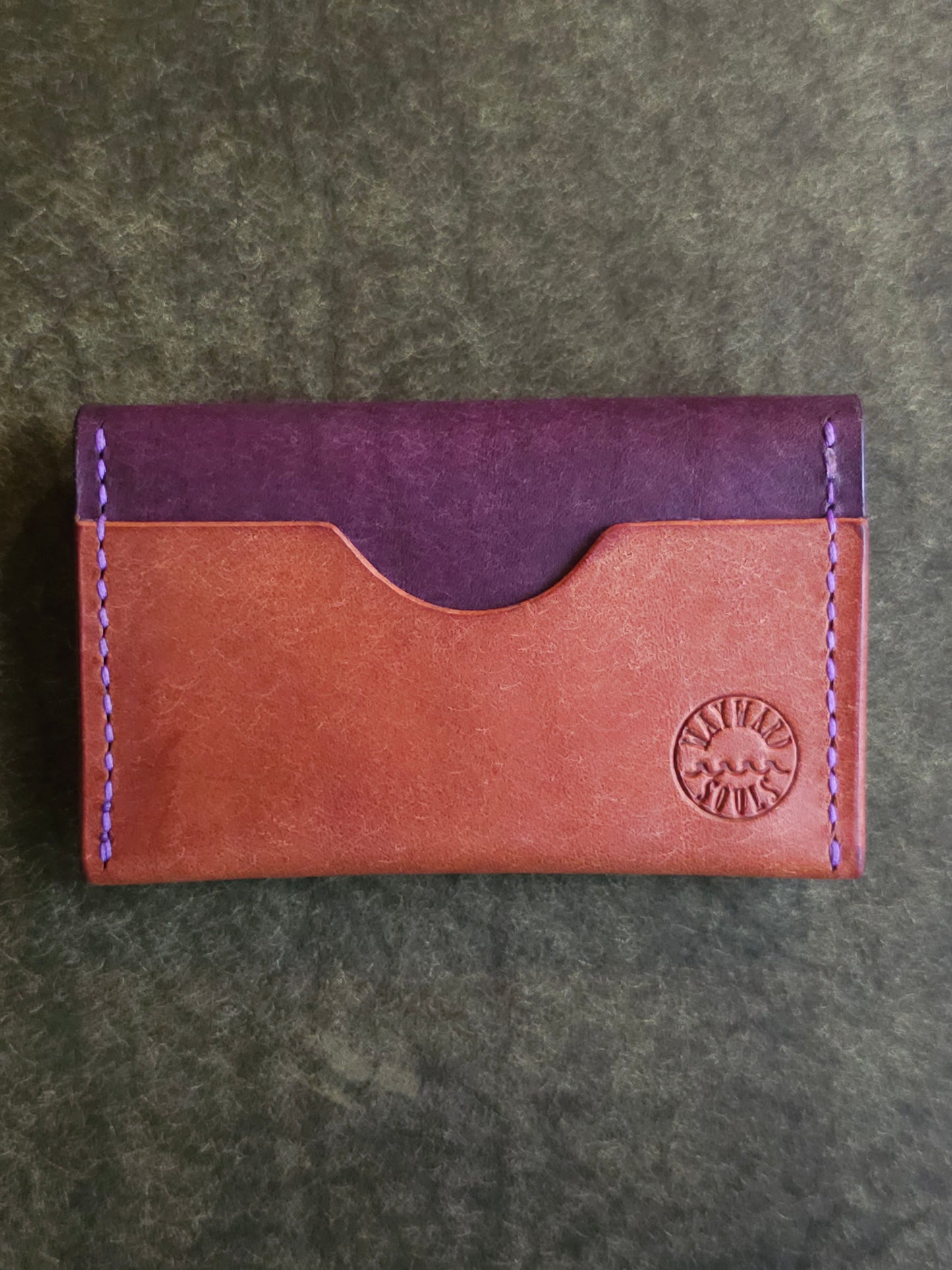 Back of card holder with a single pocket. The Wayward Souls logo in stamped in the bottom right corner.