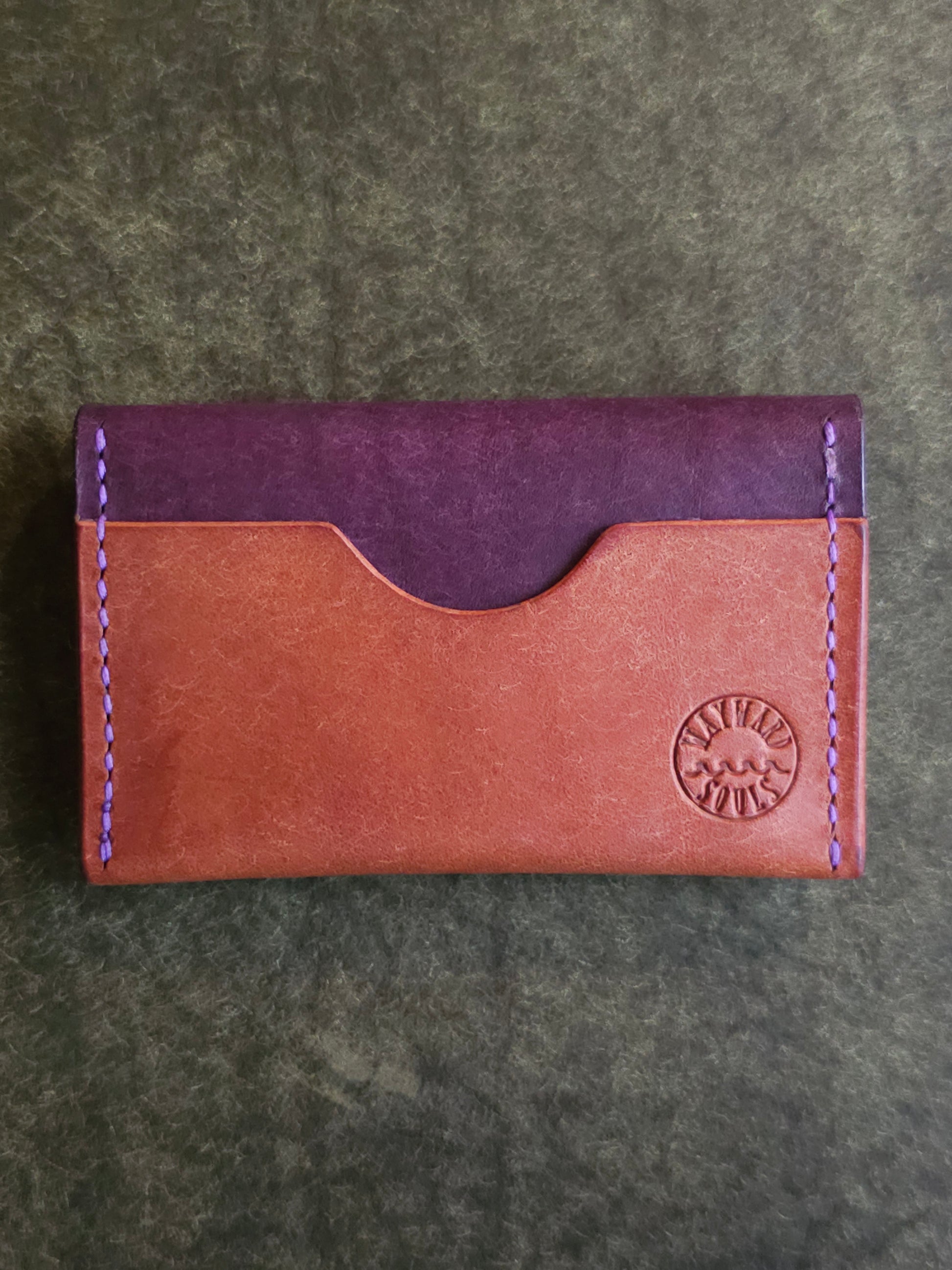 Back of card holder with a single pocket. The Wayward Souls logo in stamped in the bottom right corner.