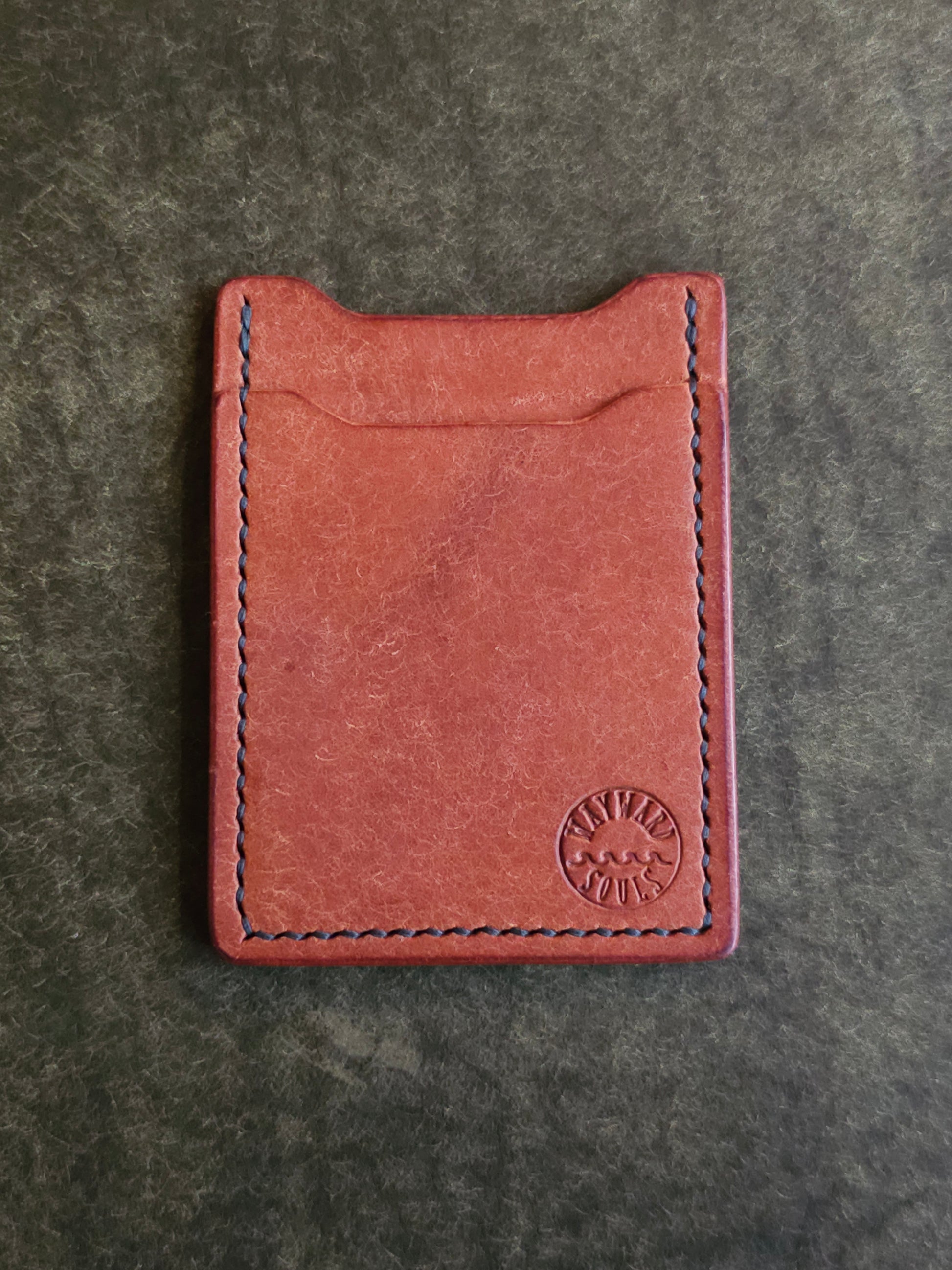 Leather card holder with angled pocket. Wayward Souls logo is stamped in the bottom right corner of the wallet.
