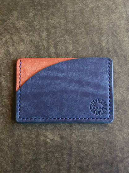 Leather card holder with pocket shaped like a sunset. Wayward Souls logo is stamped in the bottom right corner of the wallet.