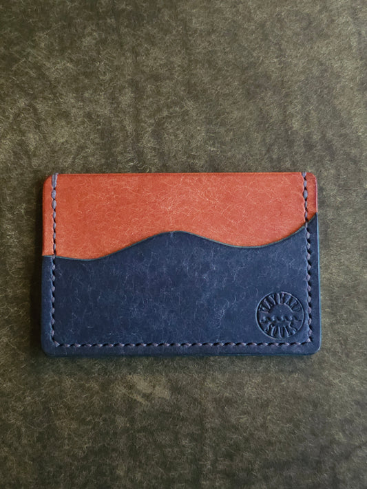 Leather card holder with pocket shaped like a wave. Wayward Souls logo is stamped in the bottom right corner of the wallet.