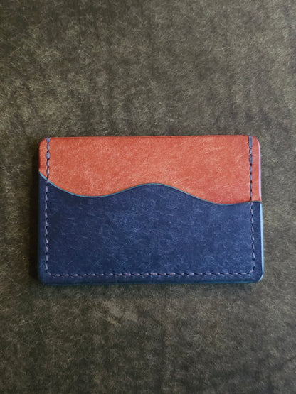 Back of leather card holder with pocket shaped like a wave.