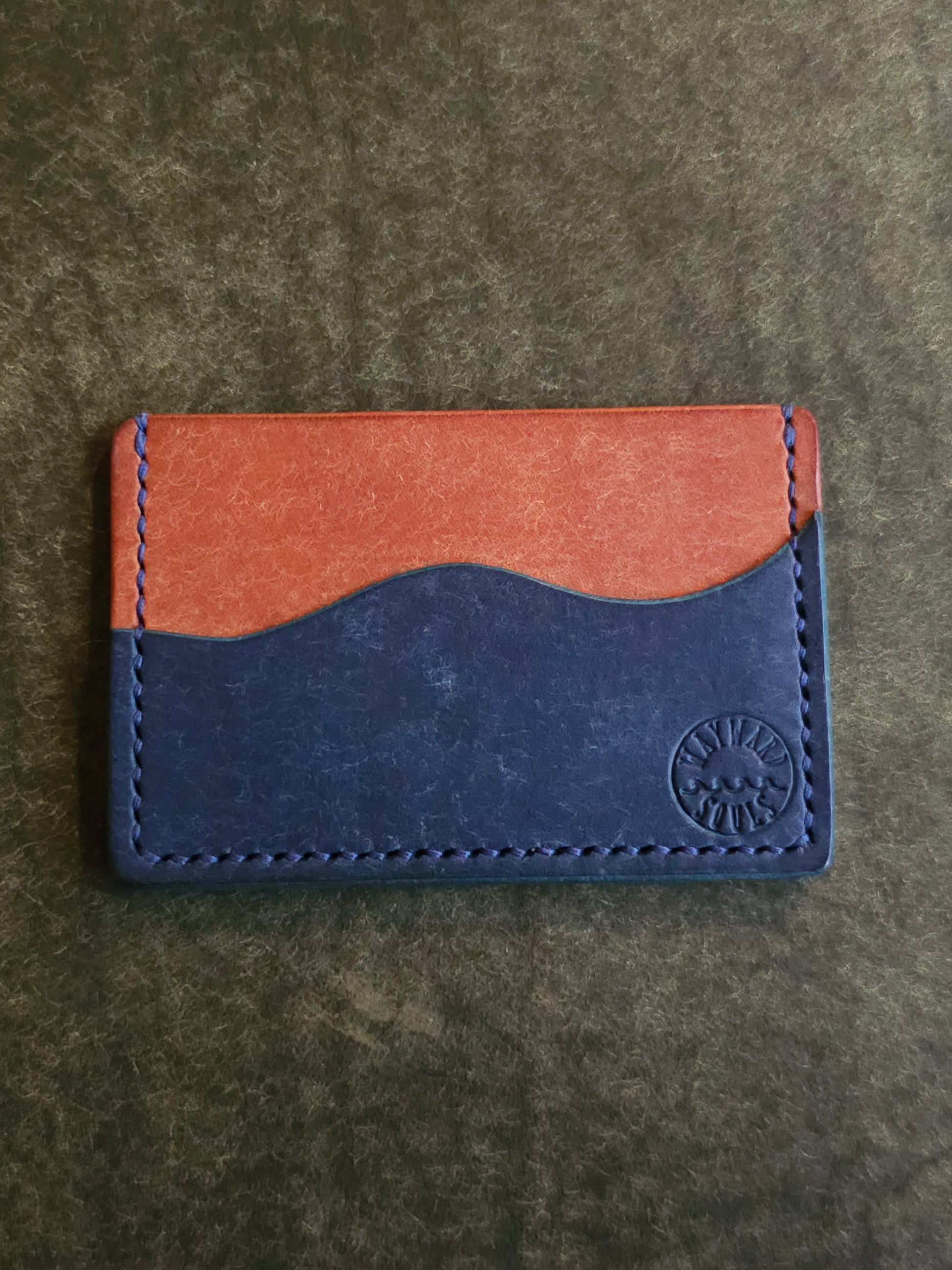 Back of leather card holder with pocket shaped like a wave.