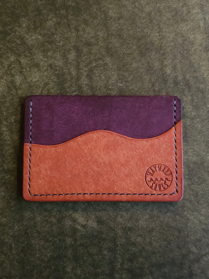 Leather card holder with pocket shaped like a wave. Wayward Souls logo is stamped in the bottom right corner of the wallet.