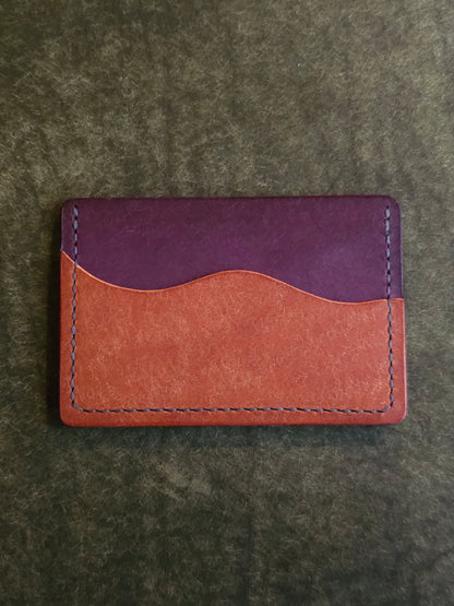 Back of leather card holder with pocket shaped like a wave.