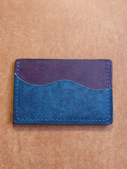 Back of leather card holder with pocket shaped like a wave.