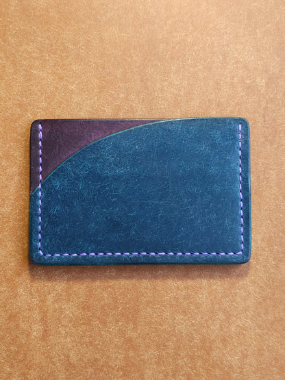 Back of leather card holder with pocket shaped like a sunset.