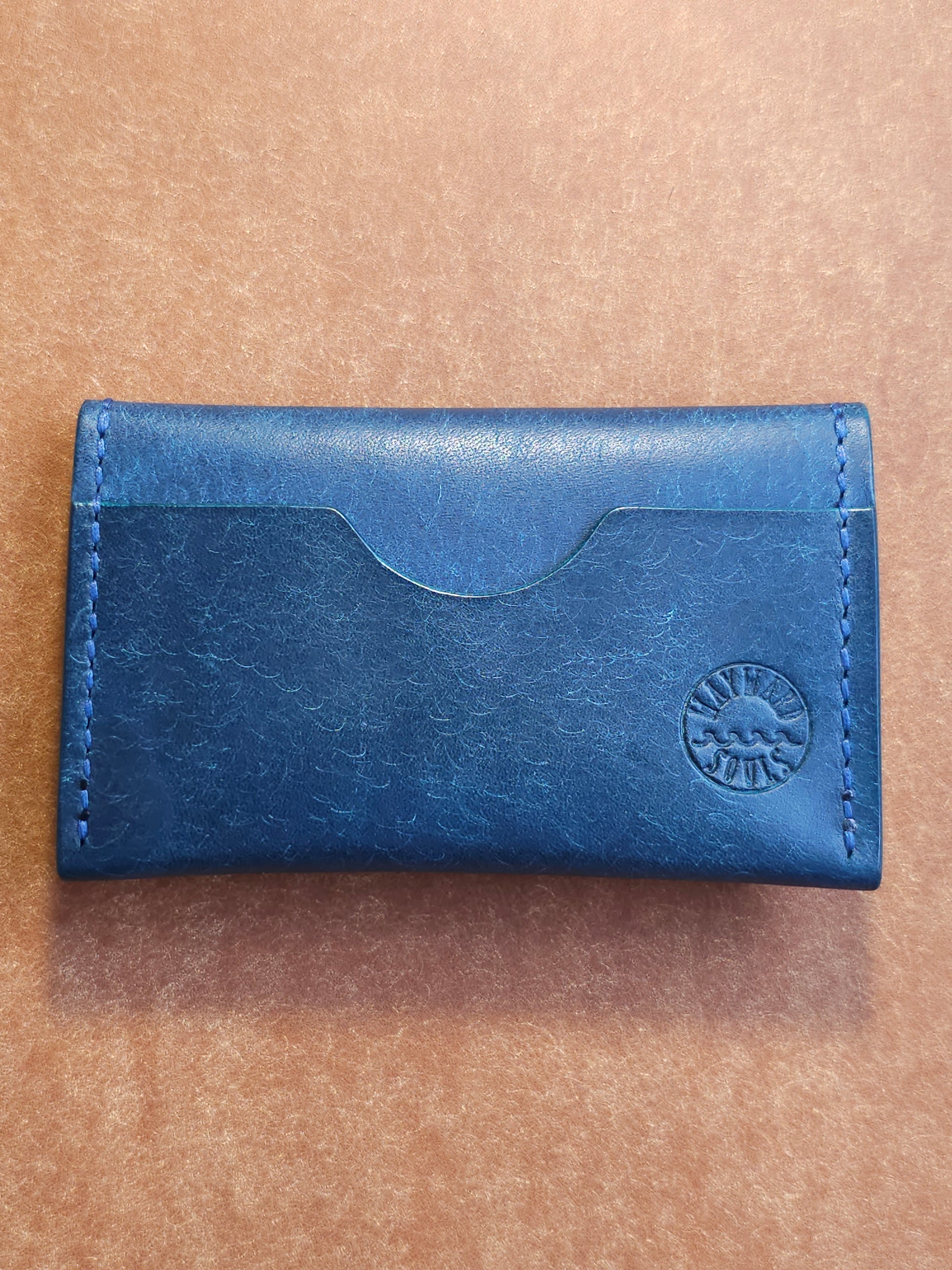 Back of card holder with a single pocket. The Wayward Souls logo in stamped in the bottom right corner.
