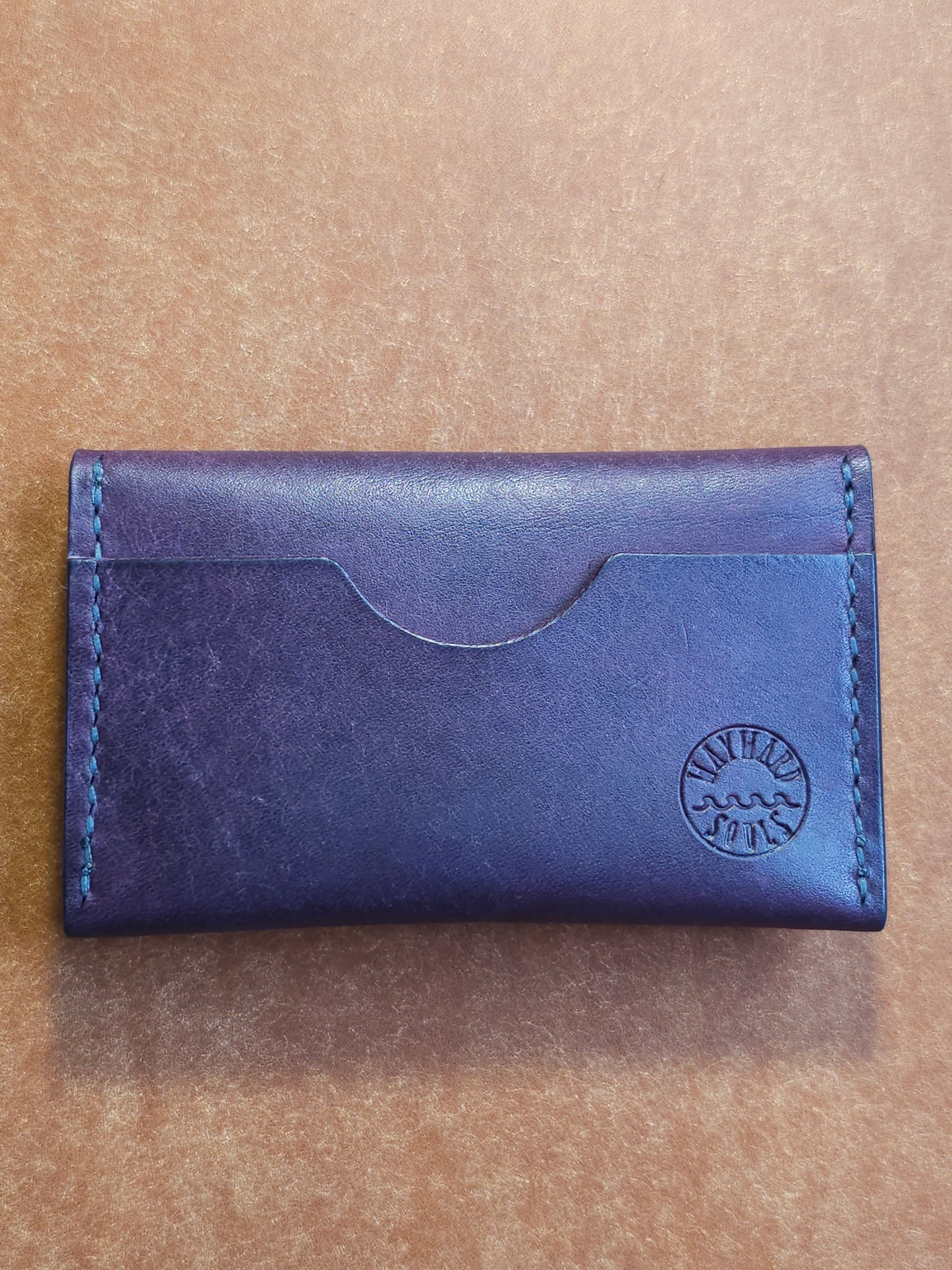 Back of card holder with a single pocket. The Wayward Souls logo in stamped in the bottom right corner.