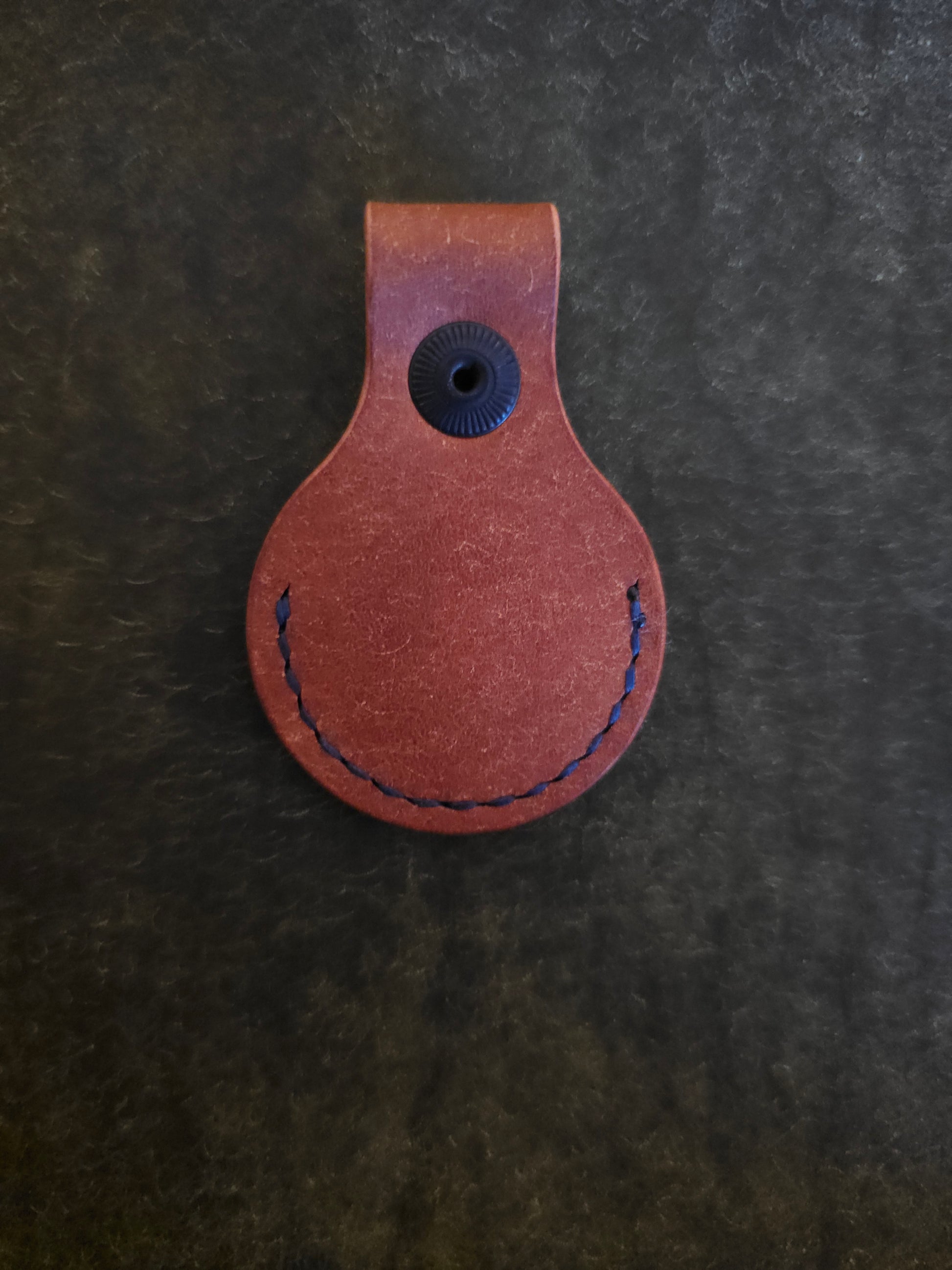 Back of circular leather air tag holder.